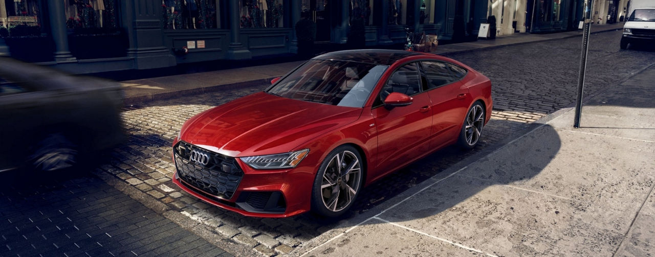 A red 2025 Audi A7 parked on a city street after leaving a Audi dealer near you.